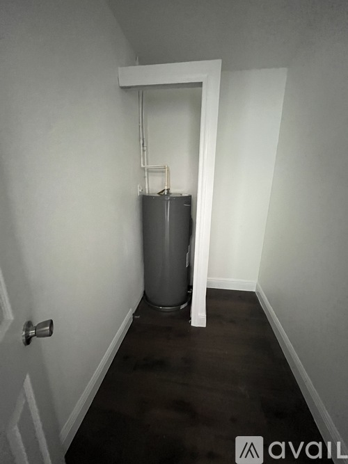 A room with a door and a water heater.