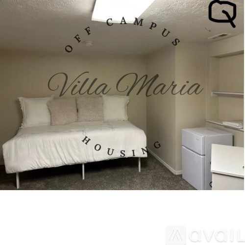 A bedroom with a bed, dresser, and a wall with the words "Villa Maria Housing" written on it.