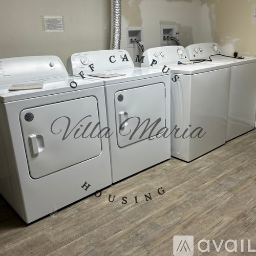A row of white washing machines with the words "Villa Maria Housing" written on them.