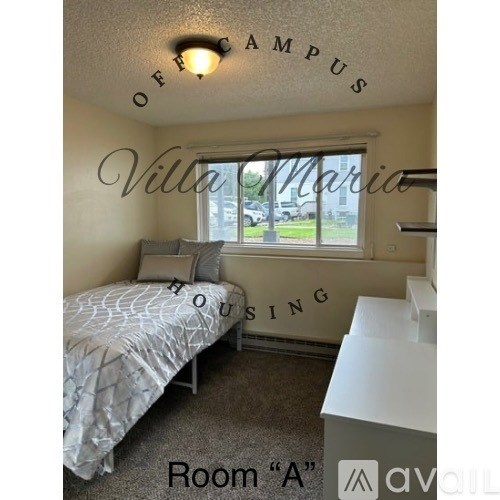 A bedroom with a bed, dresser and window with Villa Maria on the wall.