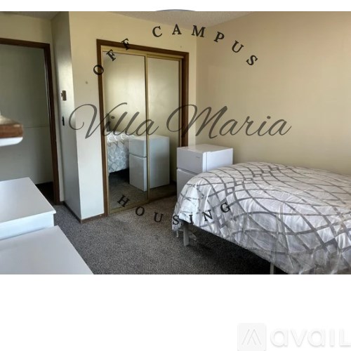A bedroom with a bed, dresser, and mirror, with the words "Campus Villa Maria" on the wall.
