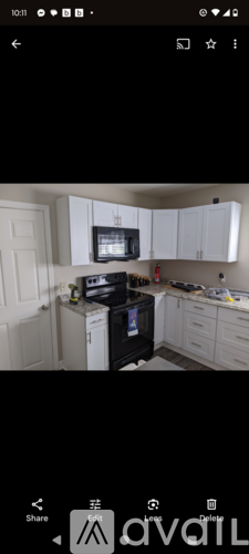 A kitchen with white cabinets and a black stove top oven.