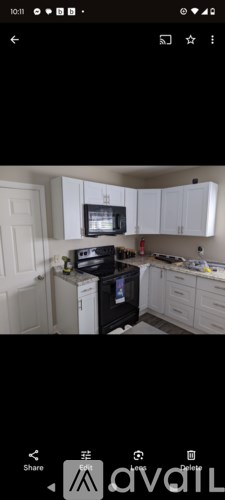 A kitchen with white cabinets and a black stove top oven.