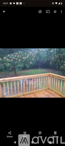A wooden deck overlooking a lush green garden.