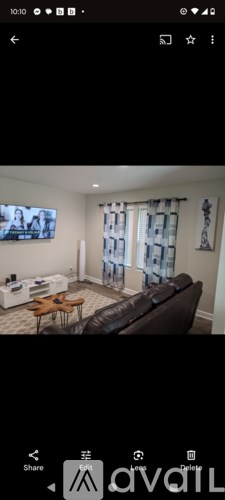 A living room with a brown leather couch and a wooden coffee table.