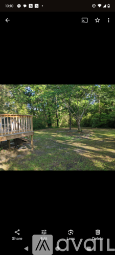 A wooden deck overlooks a grassy area with trees.