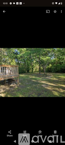 A wooden deck overlooks a grassy area with trees.