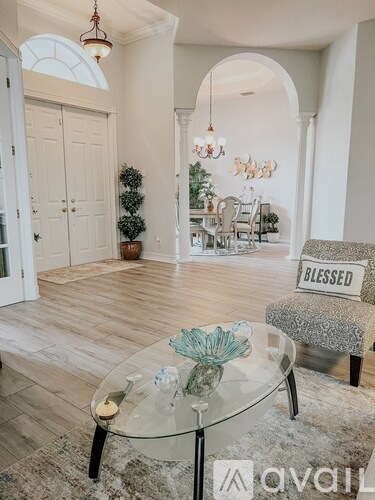A living room with a glass table and a sign that says "blessed".