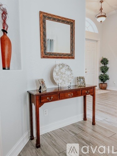 A wooden table with a mirror and vases on it.
