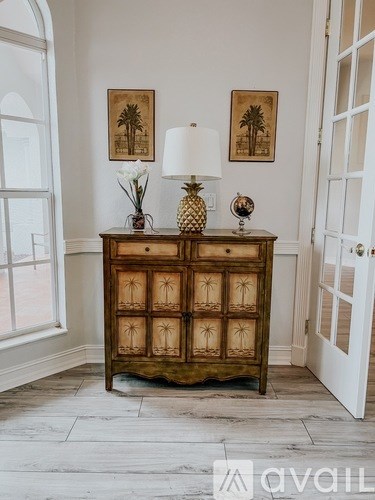 A wooden cabinet with a pineapple design is in the corner of a room.