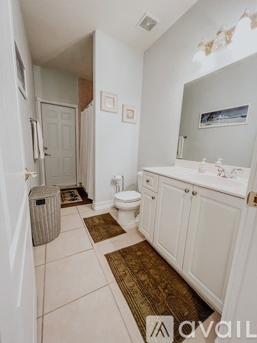 A bathroom with white cabinets and a white toilet.