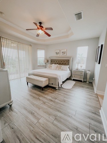 A bedroom with a bed, nightstand, and a ceiling fan.