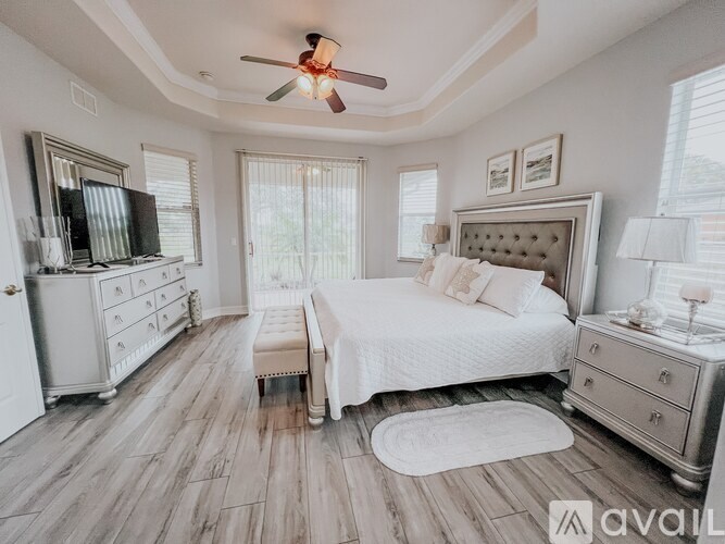 A bedroom with a bed, dresser, and television.