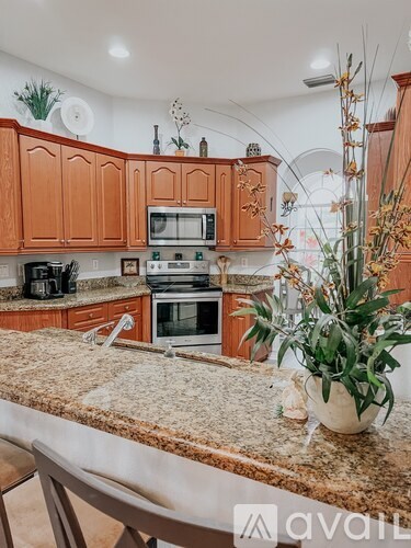 A kitchen with brown cabinets and a granite countertop.
