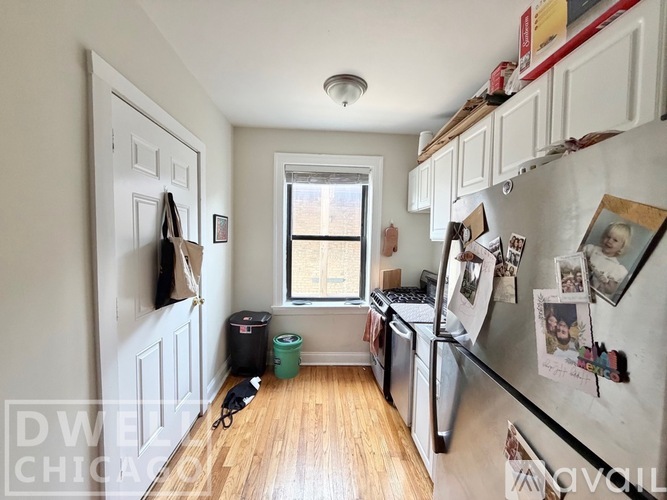A kitchen with white cabinets and black countertops.