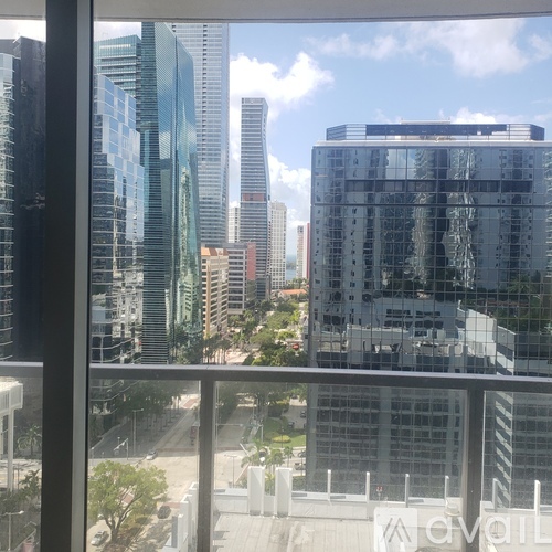A cityscape with tall buildings and a clear sky is visible through a window.