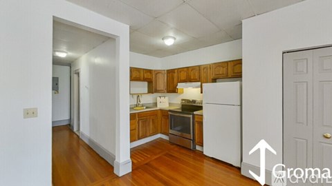 A kitchen with wooden cabinets and white appliances.