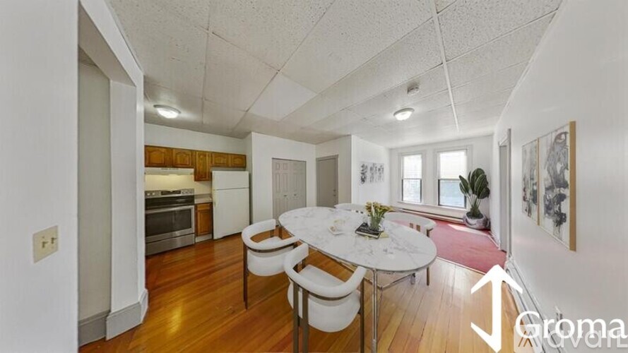 A dining room with a white table and chairs.