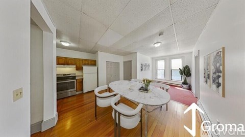 A dining room with a white table and chairs.