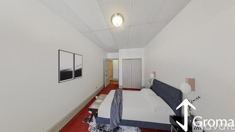 A bedroom with a bed, a nightstand, and a picture on the wall.