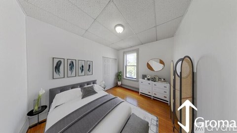 A bedroom with a bed, nightstands, and pictures on the wall.