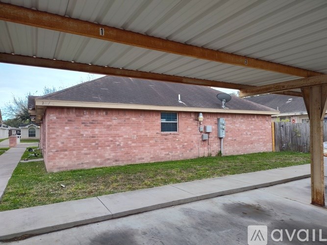A red brick house with a white roof and a wooden fence in front.