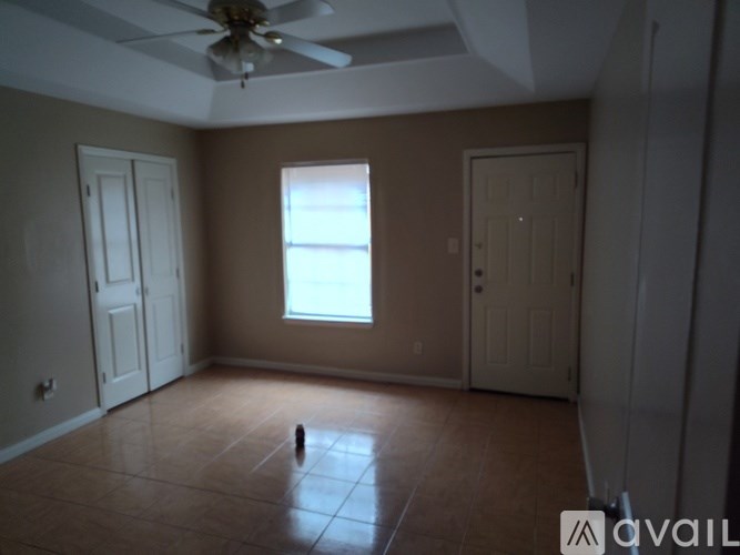 A room with a ceiling fan and a window.