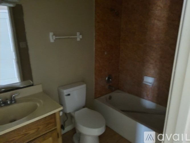 A bathroom with a toilet, sink, and bathtub.