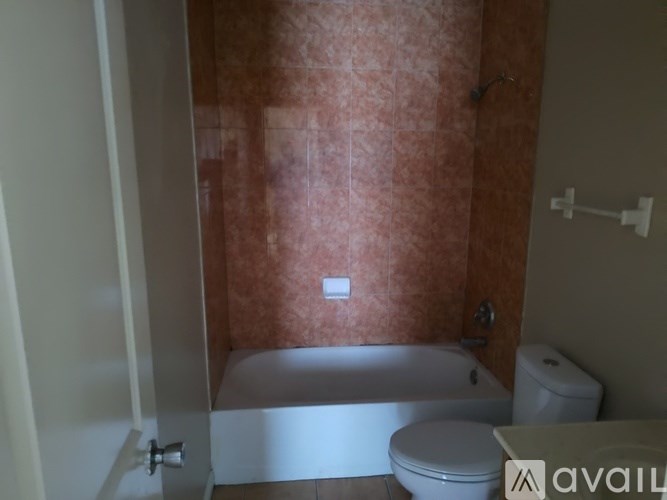 A bathroom with a toilet, tub, and shower.