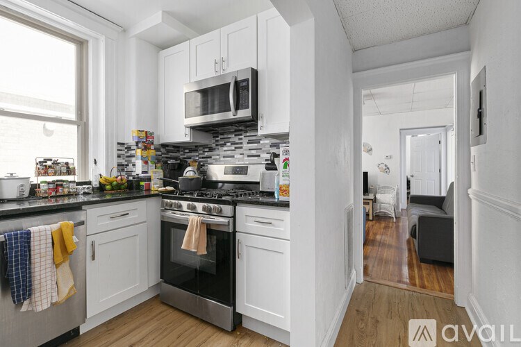 A kitchen with white cabinets and a black stove top oven.