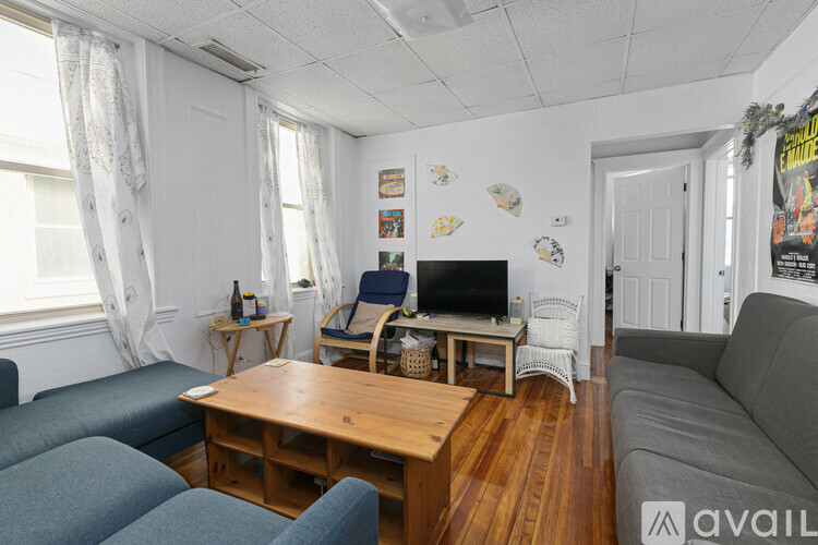 A living room with a grey couch, a wooden table, and a television.