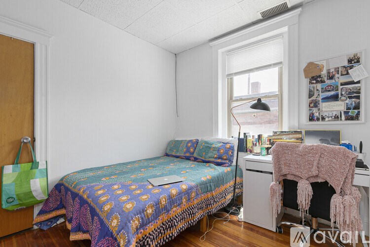 A room with a bed, a desk, and a chair.