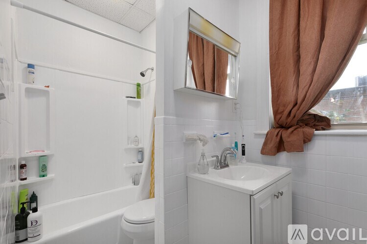 A bathroom with a white tub, sink, and toilet.