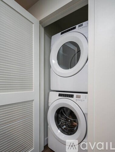 A white washing machine is in a cabinet.