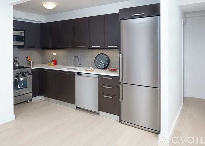 A kitchen with a stainless steel refrigerator, microwave, and oven.