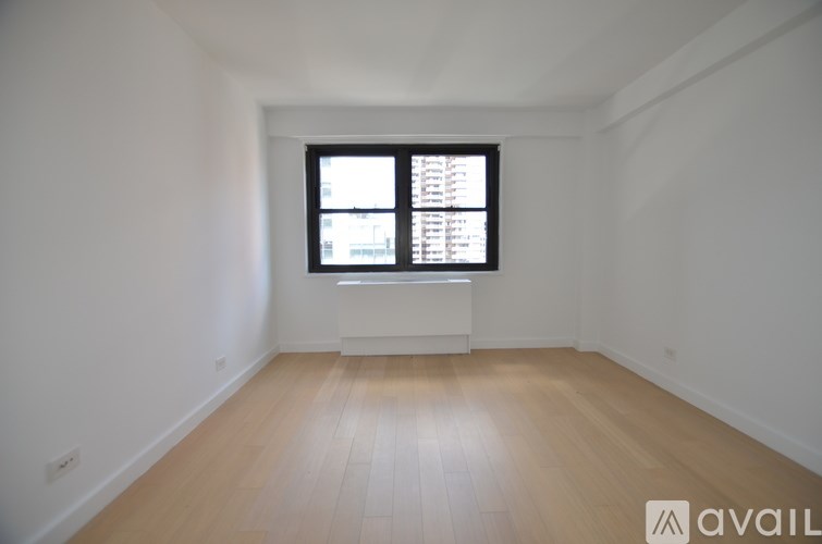 A room with a window and wooden flooring is available for rent.