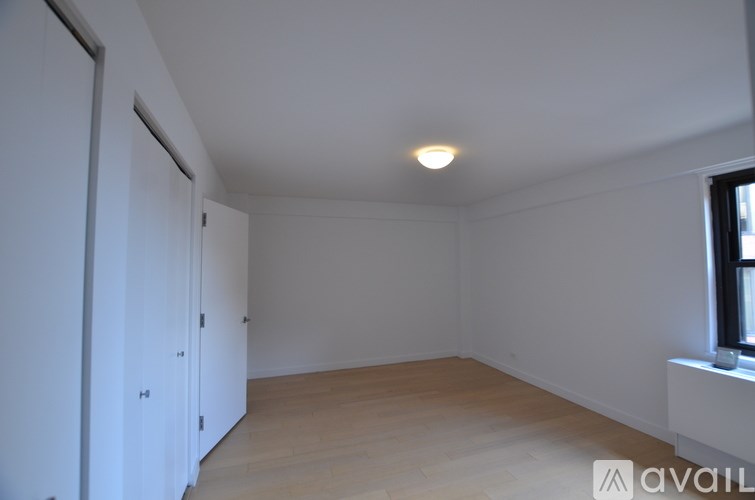 A room with a window and a wooden floor.