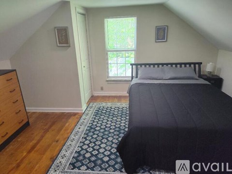 A bedroom with a bed, dresser, and window.