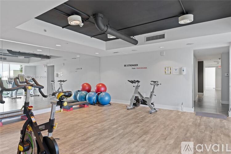 A gym with exercise equipment and a mirror on the wall.