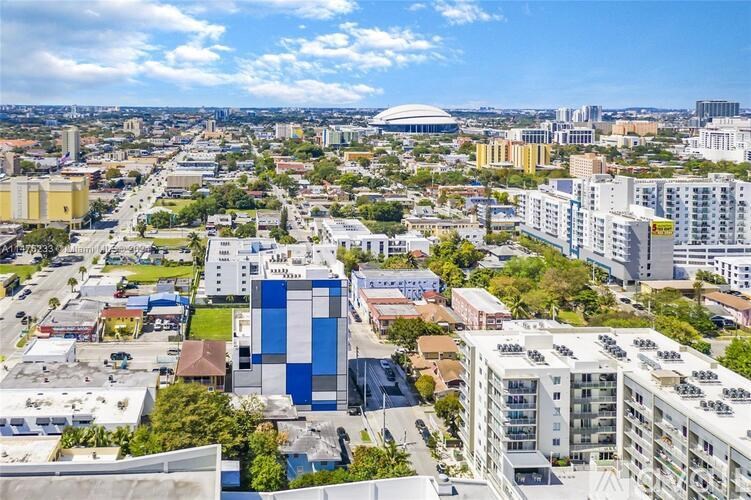 A cityscape with buildings and a large dome structure in the distance.