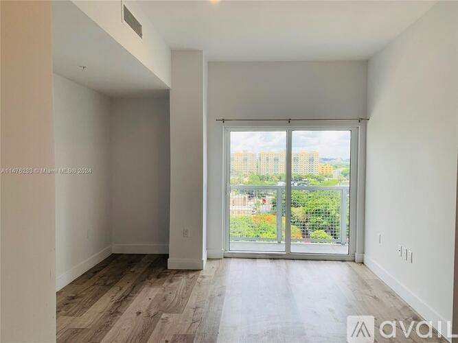 A room with a sliding glass door leading to a balcony.