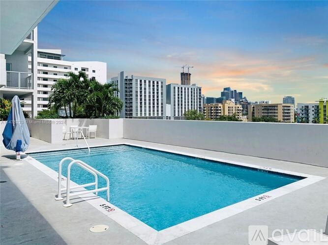 A small pool on a balcony with a cityscape in the background.
