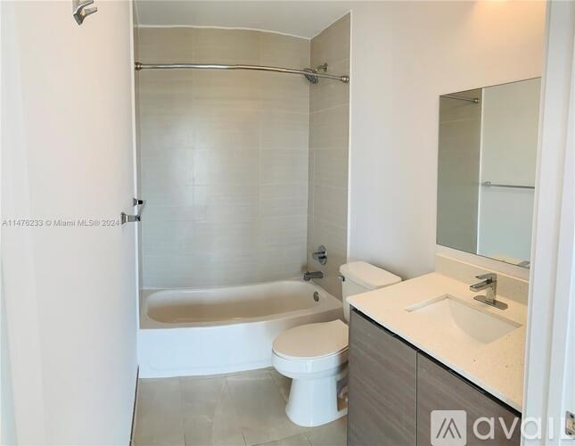 A white toilet sits next to a bathtub in a bathroom.