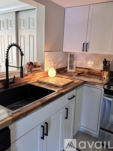 A kitchen with white cabinets and a black sink.