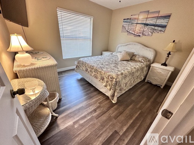 A bedroom with a bed, chair, and lamp.