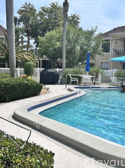 A pool with a slide and a sun lounger.