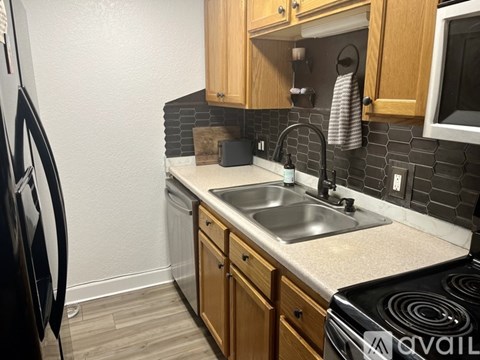 A kitchen with a black stove top oven and a black fridge.