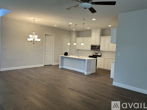 A spacious kitchen with a white island and wooden flooring.
