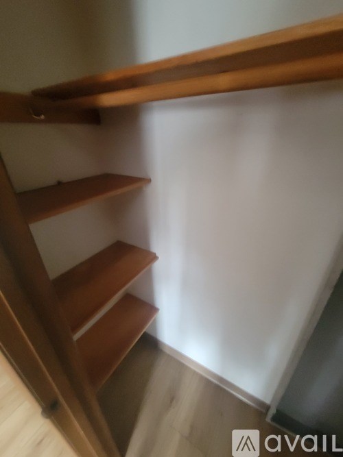 A wooden staircase with a white wall on the side.