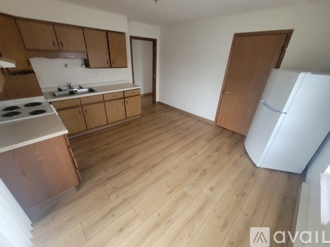 A kitchen with wooden cabinets and a white fridge.